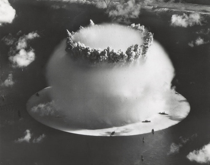 L'explosion Baker avec l'onde de choc concentrique qui recouvre les navires | Par U.S. Army Photographic Signal Corps — http://www.dtra.mil/press_resources/photo_library/CS/CS-1.cfm, Domaine public, https://commons.wikimedia.org/w/index.php?curid=443693
