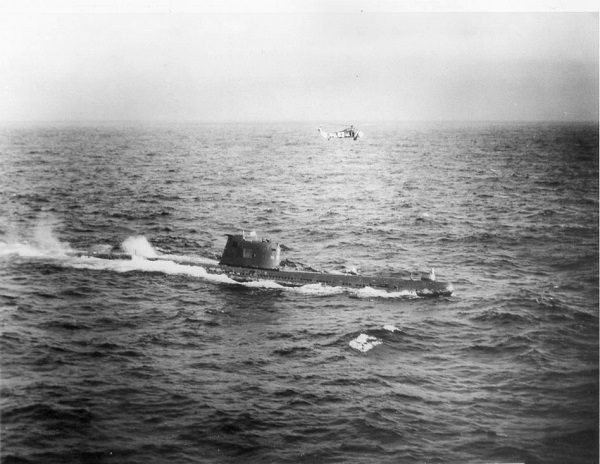 Le sous-marin B-59 en surface, avec un hélicoptère de l'US Navy en survol, dans la mer des Caraïbes près de Cuba, vers le 29 octobre 1962 | Par U.S. Navy photographer — Domaine public, https://commons.wikimedia.org/w/index.php?curid=10218466
