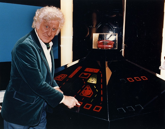 John Pertwee à côté des commandes du Tardis dans Doctor Who | Par Archives New Zealand from New Zealand — Dr Who, John Pertwee, CC BY-SA 2.0, https://commons.wikimedia.org/w/index.php?curid=51250852